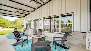 An outdoor patio with Adirondack chairs, a fire pit, and a welcome sign.