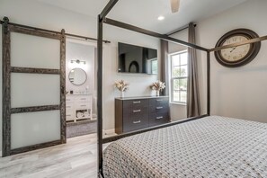 Une chambre à coucher avec un lit, une commode, un miroir et une horloge au mur.