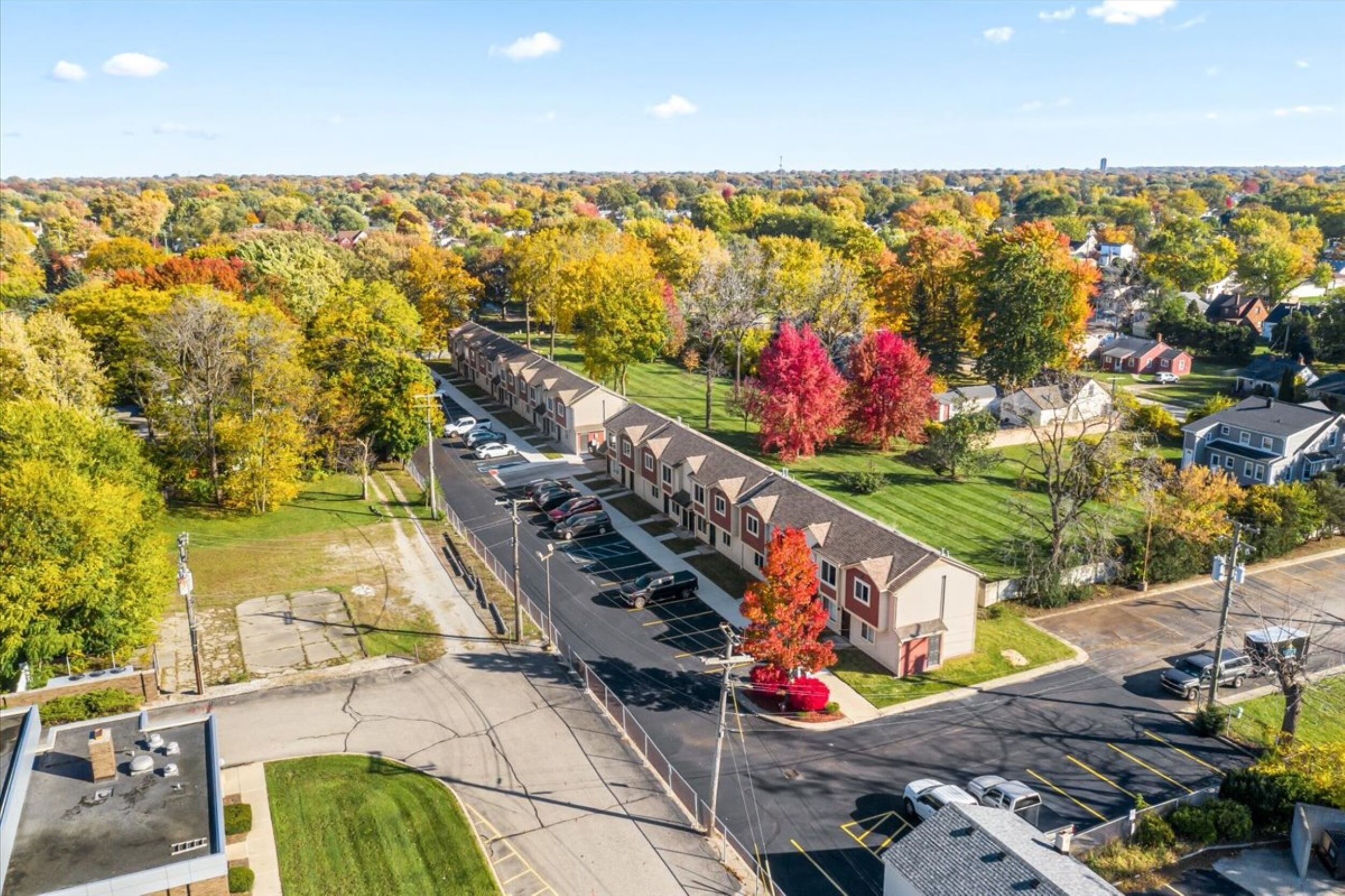 A row of single-story buildings with a parking lot in front.