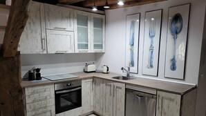 Een keuken met witte kastjes, een broodrooster, een waterkoker en een vaatwasser.