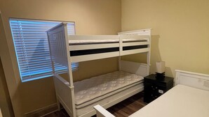 A room with bunk beds, a ceiling fan, a window with blinds, and a bedside table. - Guest house at a private resort in Good Hope Area (Perris)