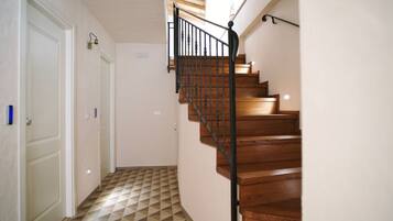 Una escalera de madera con barandilla de metal negro que conduce a una plataforma.