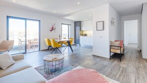 Un salon moderne avec un canapé, une table basse et un coin repas doté de chaises jaunes.