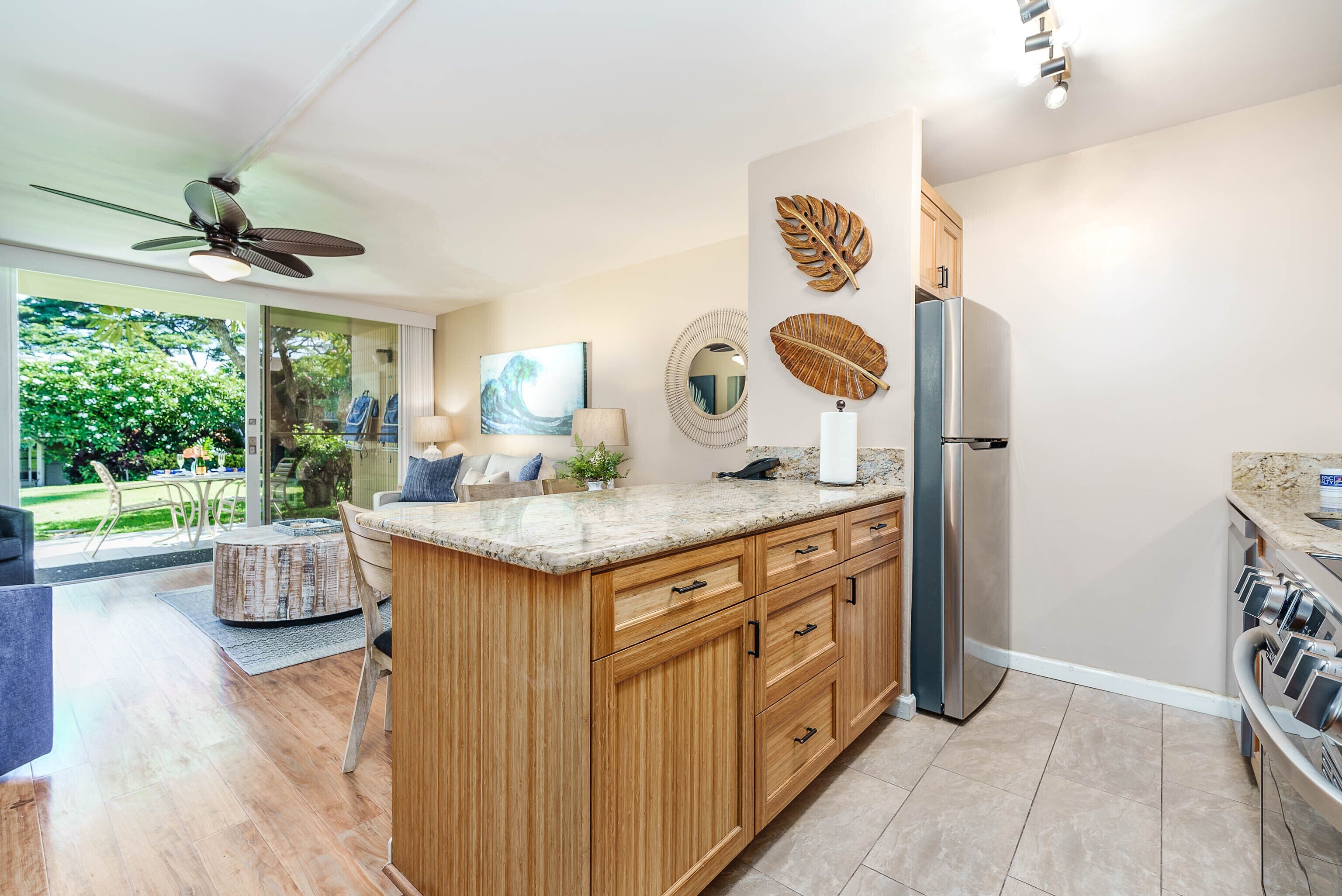 A modern kitchen with wooden cabinets, a granite countertop, and a stainless steel refrigerator.