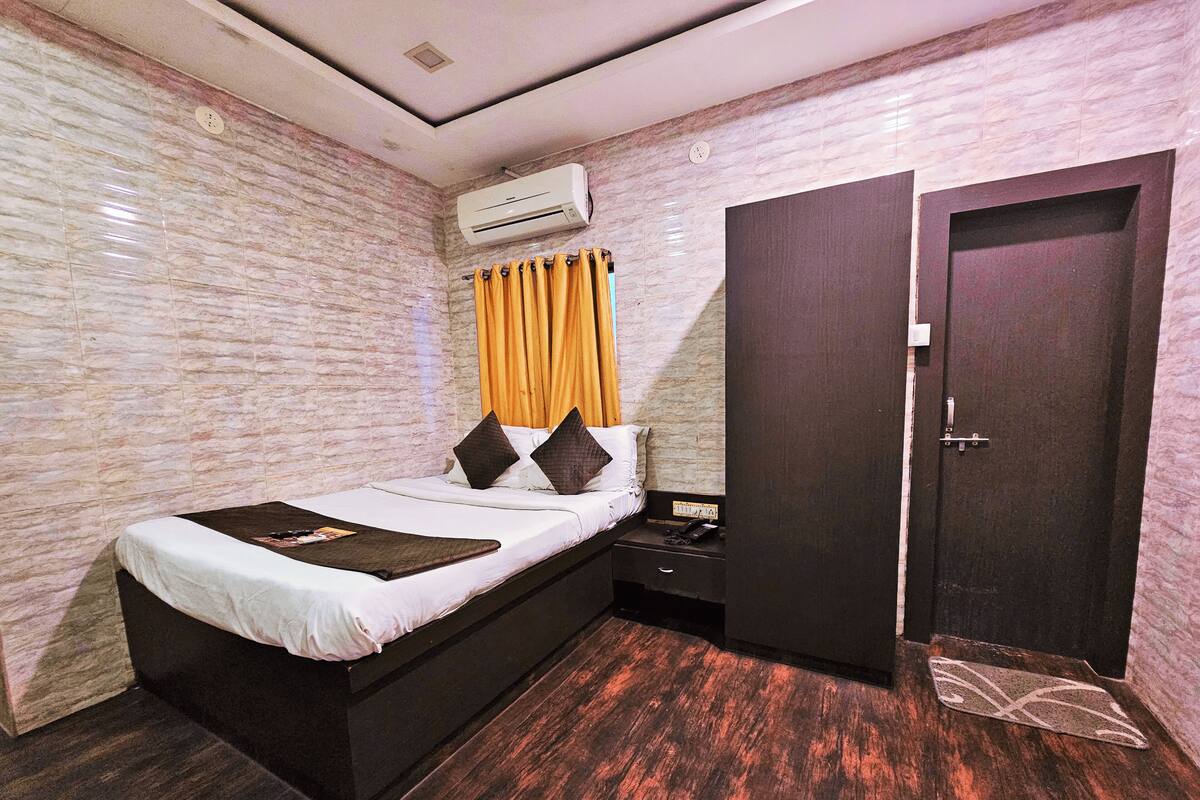 A bedroom with a bed, bedside table, and a wardrobe.