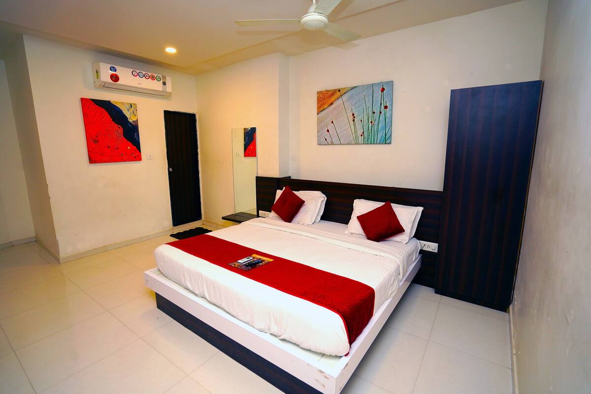 A modern bedroom with a large bed, a ceiling fan, and artwork on the walls.