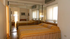 A bedroom with two beds, a large mirror, and a window. - Outstanding apartment with amazing views in heart of Palermo verde (Buenos Aires)