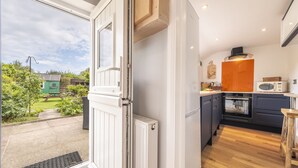 Eine moderne Küche mit großem Fenster, Einbauofen und Mikrowelle.