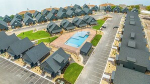 A residential area with multiple houses, a swimming pool, and a parking lot.
