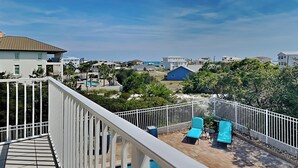 A balcony with a view of a residential area, including houses and greenery.