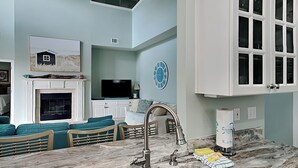 A modern kitchen with a marble countertop, stainless steel sink, and a built-in oven.