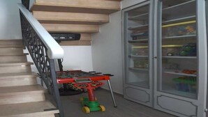 A staircase with a handrail, a toy foosball table, and a glass-fronted cabinet with shelves. - The little house among the olive trees (Pieve A Elici)