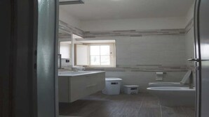A modern bathroom with a large mirror, a window, and a sink. - The little house among the olive trees (Pieve A Elici)