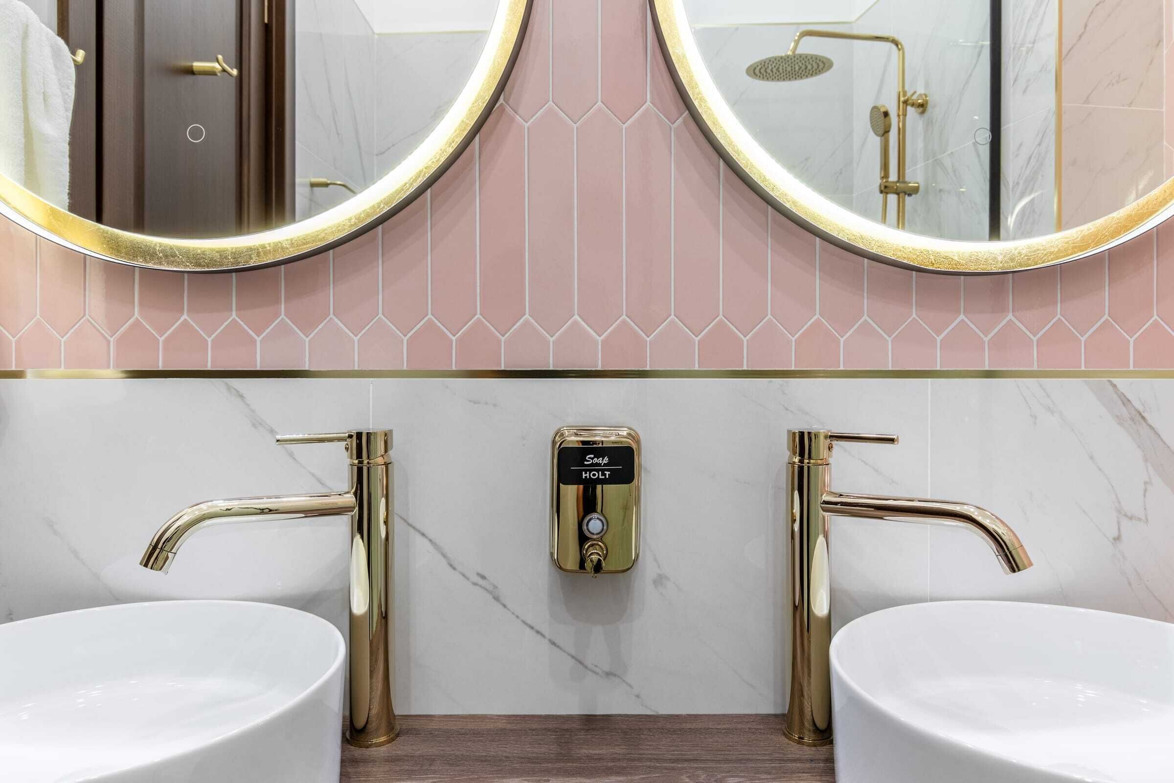 A bathroom with two sinks, a mirror, and a shower.