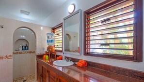 A bathroom with a sink, mirror, and a water dispenser. - Bright and airy beachfront villa located in Soliman Bay with a New Pool (Tulum)