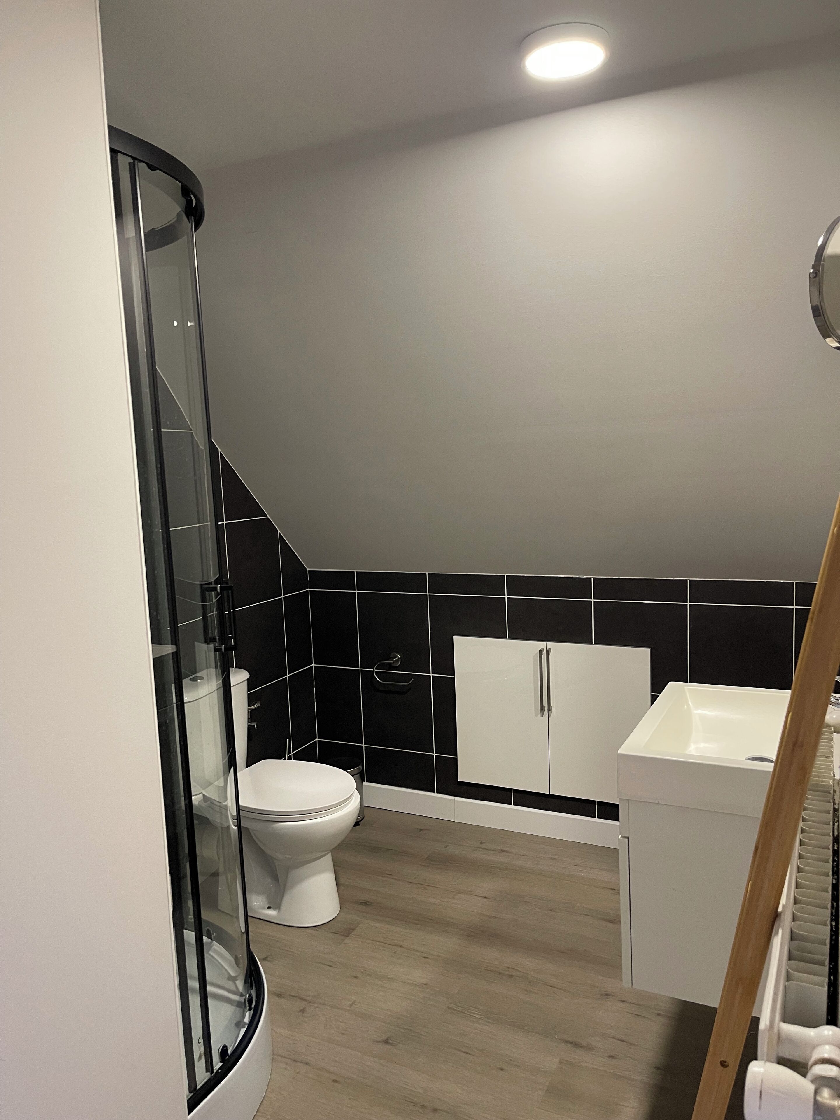 Une salle de bain avec une douche à parois de verre, des toilettes et un lavabo.