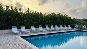 A swimming pool with lounge chairs and a hedge in the background. - Beachfront! 3rd Floor Corner Unit, Enjoy Sunrise to Sunset (Stuart)