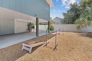 A covered outdoor area with a wooden bench, a metal structure, and a water heater.
