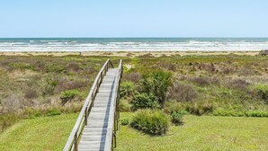 A wooden boardwalk leading to a beach with dunes and sparse vegetation. - Beachfront w/POOL ON DECK, Private Dune Walkover, 5 Bedrooms (Galveston)