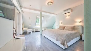A modern bedroom with a large bed, a desk, and a chair.