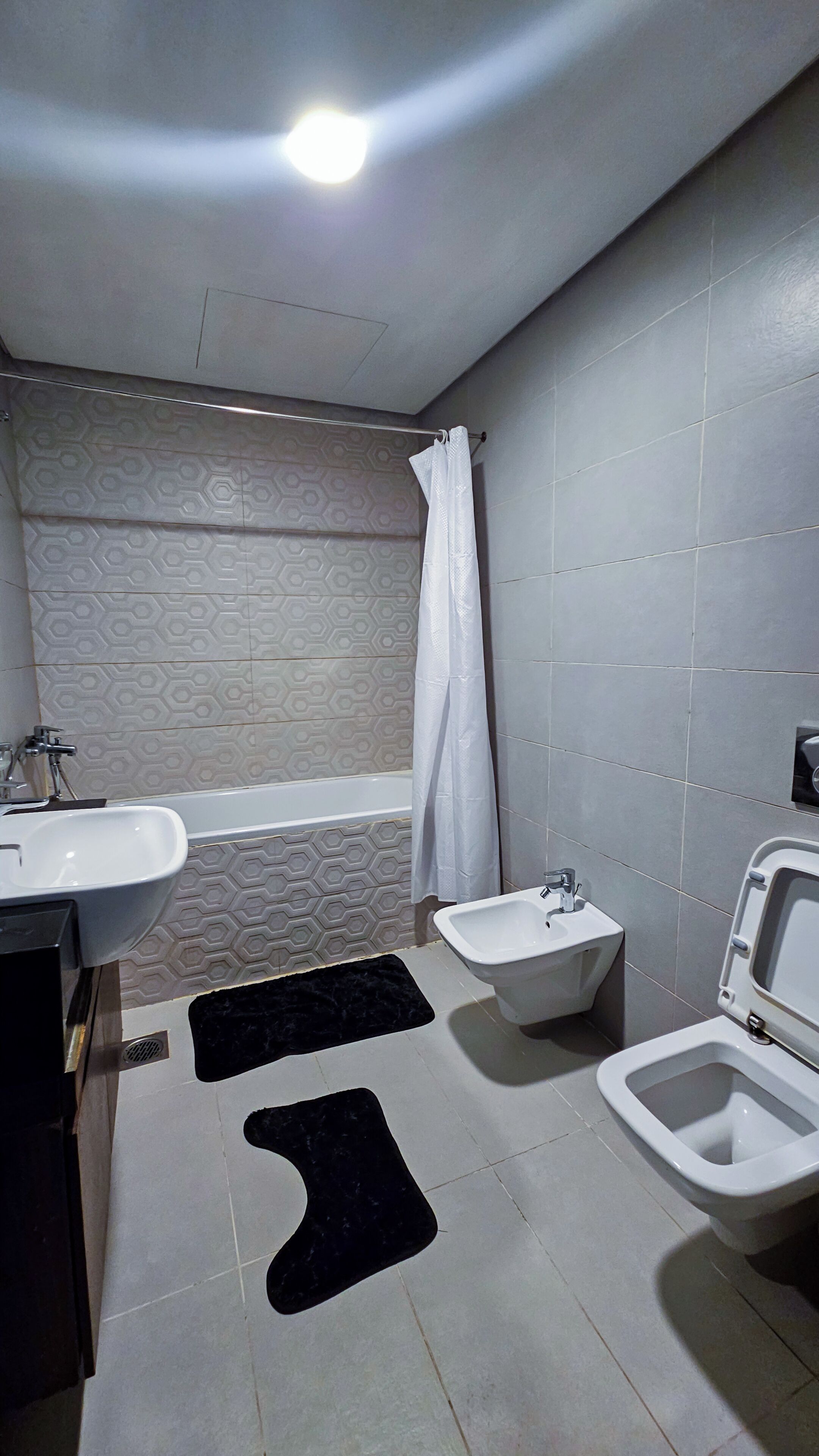 Un baño con bañera, bidé, inodoro y lavamanos.