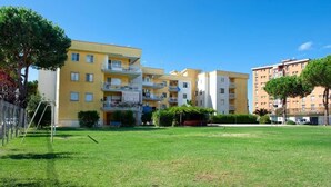 A residential building with multiple balconies, a well-maintained lawn, and a clear blue sky. - Villa Regina Home - 120sqm, 3 bedrooms, 1 parking spot  (Boscoreale)