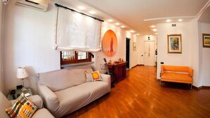 A living room with a sofa, a guitar, and a wooden floor. - Villa Regina Home - 120sqm, 3 bedrooms, 1 parking spot  (Boscoreale)