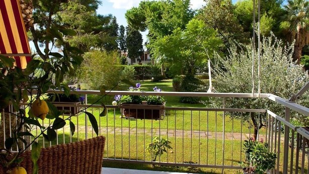 A balcony with a view of a well-maintained garden, featuring a variety of trees and shrubs. - Villa Regina Home - 120sqm, 3 bedrooms, 1 parking spot  (Boscoreale)