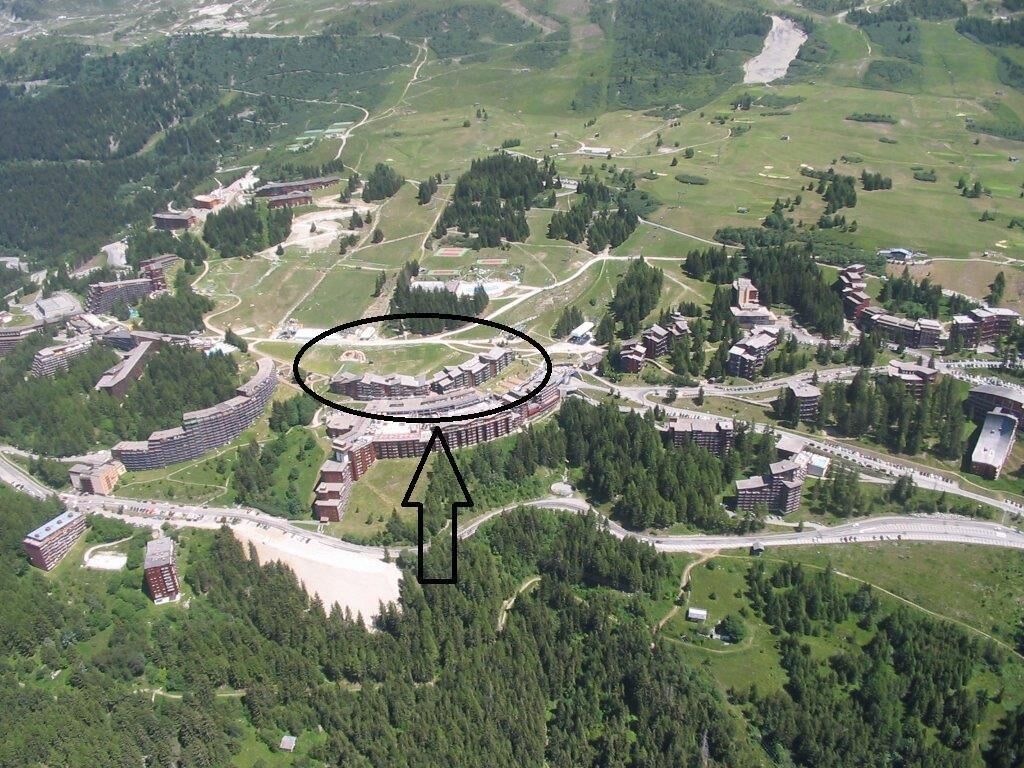 Vue aérienne d’un complexe hôtelier doté d’un ensemble de bâtiments circulaires, entouré de verdure et de routes.