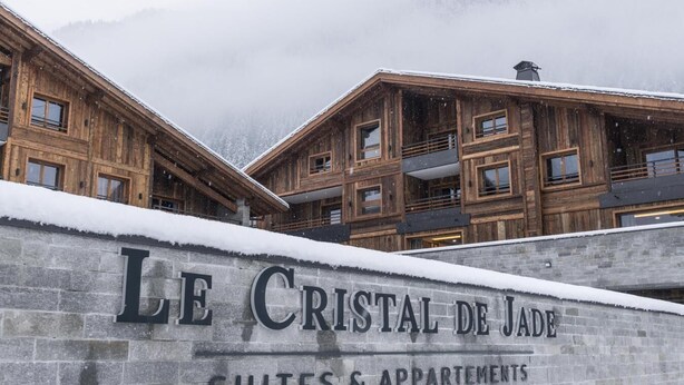 A wooden building with a sign reading "Le Cristal de Jade Suites & Apartments". - Wifi, 50m from ski lifts, fitness, swimming pool, sauna, hammam, balcony, ski locker, 90m², Chamonix (Chamonix-Mont-Blanc)