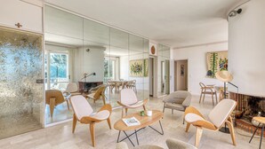 Un salon moderne doté d’une cheminée, de sièges confortables et d’un grand miroir.