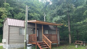 A cabin with a wooden deck, a front door, and a small porch. - Judy's Place - 1BR, 1 Bath w/ Q, K, and Twin bed. Full kitchen. (Putney)