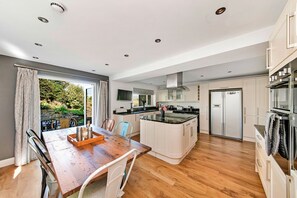 Enjoy meals in the kitchen with a central island, dining table, and stainless steel appliances.