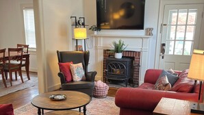 A living room with red leather sofas, a wooden coffee table, a fireplace, and a ceiling fan. - Great 3BR home in Lynchburg, great location near colleges, great amenities (Lynchburg)