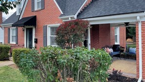 A brick house with a covered porch, a chimney, and a garden with various plants. - Great 3BR home in Lynchburg, great location near colleges, great amenities (Lynchburg)