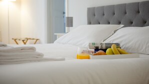A neatly made bed with white linens, a bedside lamp, and a fruit bowl with bananas and oranges. - APT Rome 5 BDRM’s (Roma)