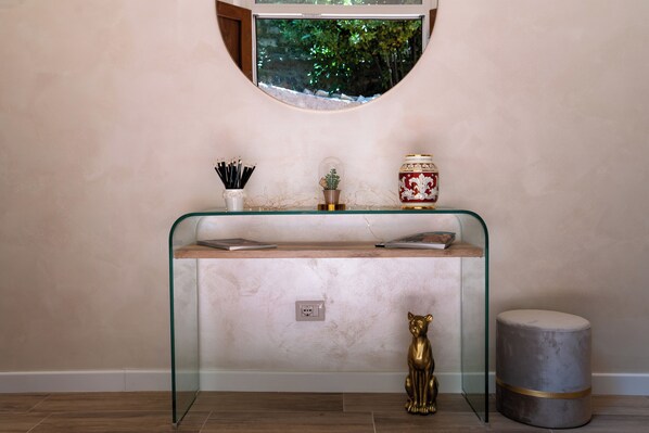A modern bathroom with a glass vanity, a small potted plant, and a decorative gold statue. - Beautiful, modern three-room apartment for 4 people, with 2 bedrooms, 2 bathrooms, a laundry room, and a parking space (Perugia)