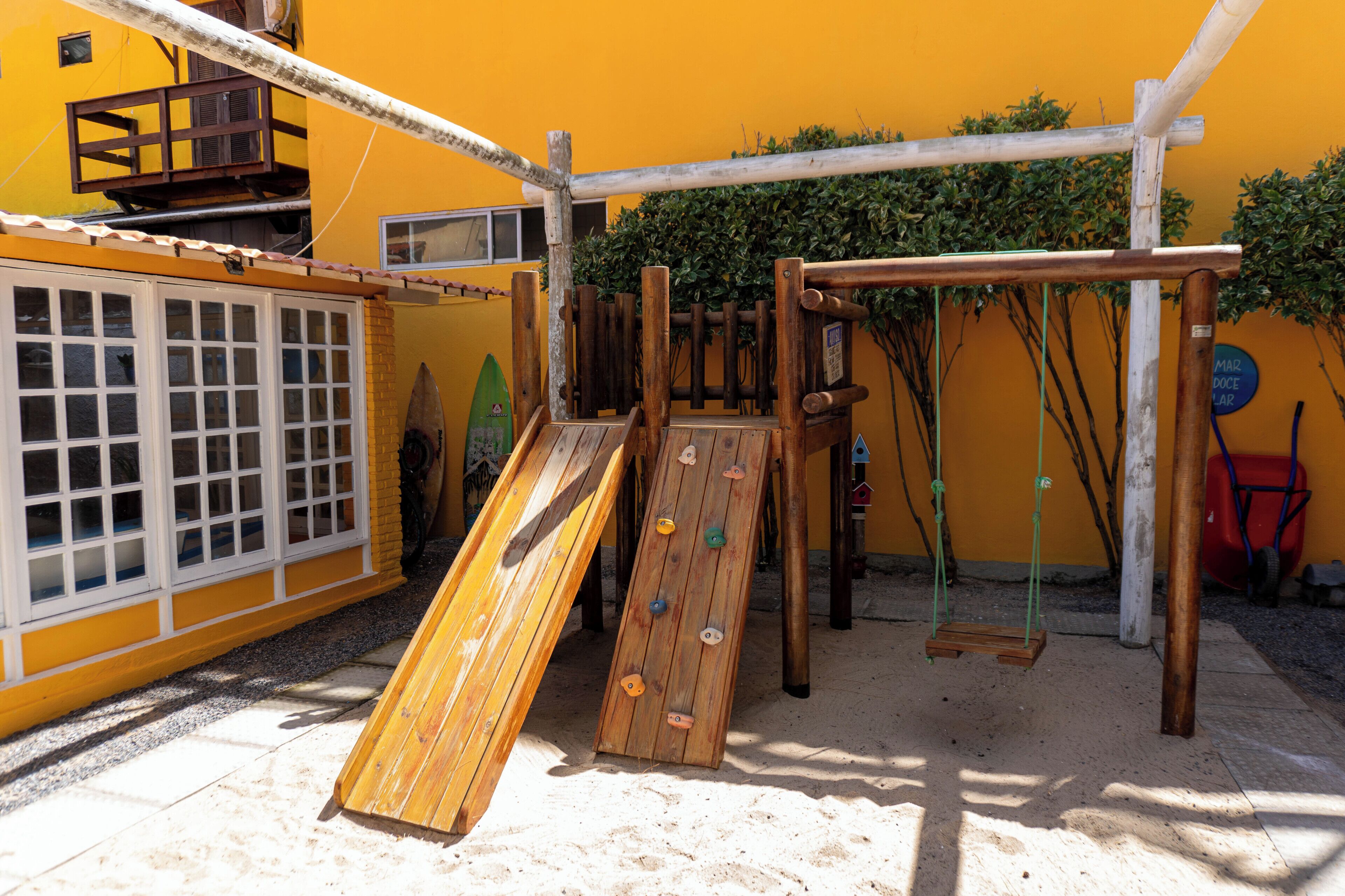 Un parque infantil con muros de escalada y columpios.