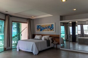 A modern hotel room with a large bed, a view of the outdoors, and a painting on the wall.
