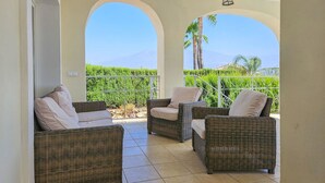 A balcony with wicker furniture and a view of a vineyard. - 5 bed villa with pool in Cerros de Aguila (Mijas Costa)