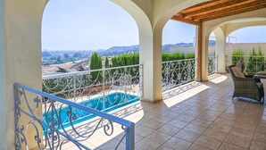 A balcony with a pool, outdoor furniture, and a view of the countryside. - 5 bed villa with pool in Cerros de Aguila (Mijas Costa)