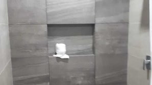 A shower with tiled walls and a shelf. - 9 Estrellas Hotel (Comitan de Dominguez)