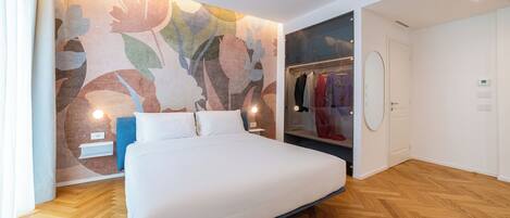 Un dormitorio moderno con una cama grande, un armario y una pared con estampado floral.