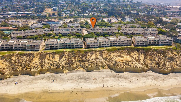 An aerial view of a coastal residential area with modern apartment buildings, a sandy beach, and a rocky cliff. - Ocean View Condo w/ Beach Access!Walk to Del Mar Track/Fair & Solana Train Stop (Solana Beach)