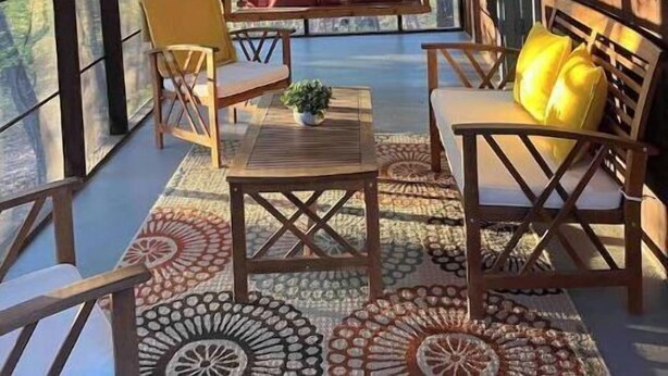 Tunnelmallinen huone, jossa on puinen katto, riippuvalaisimet, suuret ikkunat sekä oleskelualue, jossa on pöytä ja tuolit.