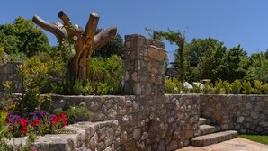 A stone wall with a wooden sculpture and a paved area with steps. - Resort Ravella: Lord Executive room (Sant´Agata sui Due Golfi)