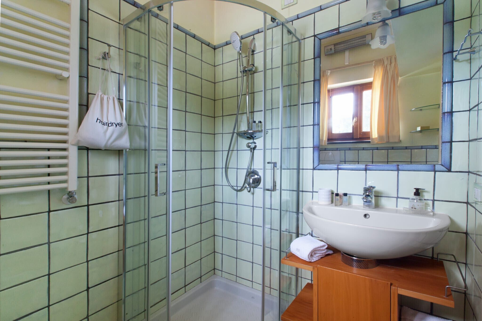 Une salle de bain avec une douche à parois de verre, un lavabo blanc et un miroir au-dessus.