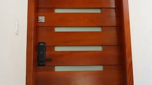 A wooden door with horizontal slats and a modern electronic lock. - Torre Altamar (Mazatlán)