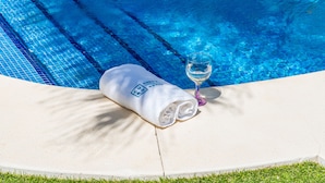 A poolside area with a towel and a glass of water.
