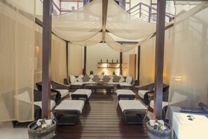 A spacious lounge area with wicker furniture and a central seating arrangement.
